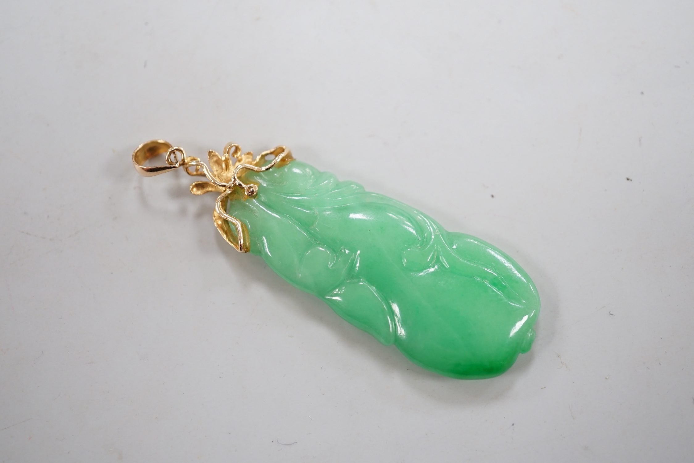 A Chinese yellow metal mounted carved jade pendant, overall 51mm.